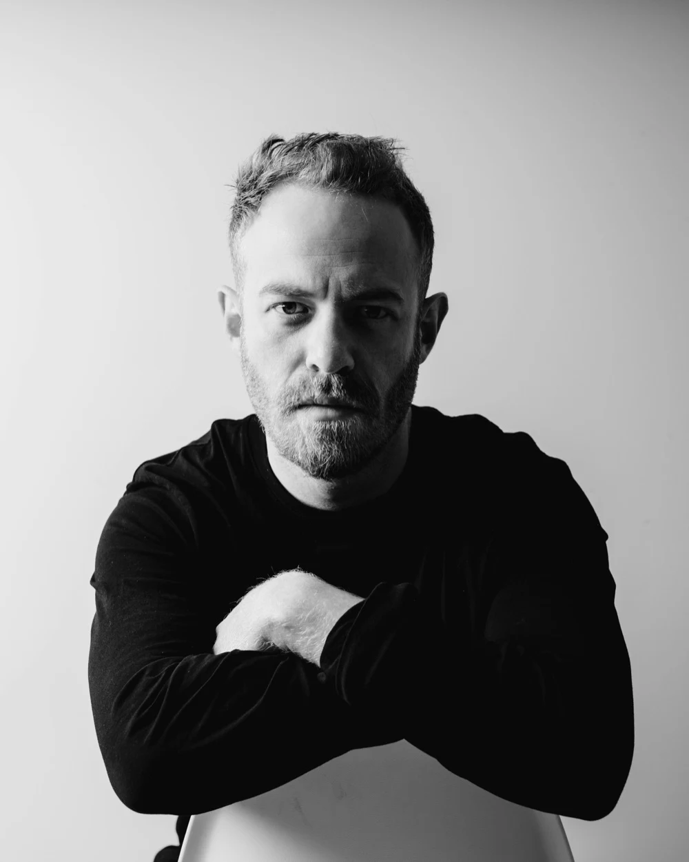 Black-and-white portrait of Peter Fray seated and facing the camera